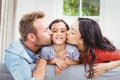 Mother and father kissing daughter at home Royalty Free Stock Photo