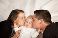 Mother and father kissing their baby girl Royalty Free Stock Photo