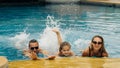 The mother and father with little daughter have fun in the pool. Mom and dad plays with the child. The family enjoy Royalty Free Stock Photo