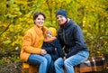 Mother, father and little son sit on a plaid on a log in the autumn park and spend time together Royalty Free Stock Photo