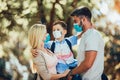 Mother,father and little son wearing face protective medical mask for protection from virus disease in park