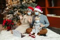 Mother and father in Santa hats and face masks with baby girl calling family on video call. Distant remote holiday celebration Royalty Free Stock Photo