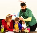 Mother, father and son in bunny ears preparing for Easter. Rabbit family painting eggs. Royalty Free Stock Photo