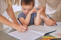 Mother and father teaching little son during homeschool class at home. Autistic cute little caucasian boy learning how Royalty Free Stock Photo