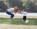 Mother, father and their little son are playing with the ball on the lawn. Royalty Free Stock Photo