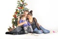 Mother, the father and their small child sits near Christmas tree Royalty Free Stock Photo
