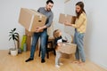 Family carry boxes to a stack, they are moving out from an old apartment Royalty Free Stock Photo