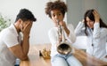 Mother and father trying to play chess while their child plays trumpet Royalty Free Stock Photo