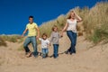 Mother, Father and Two Boys Family Walking in Sand Dunes on a Beach Royalty Free Stock Photo