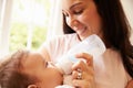 Mother Feeding Baby Boy From Bottle At Home Royalty Free Stock Photo