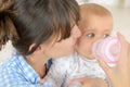 mother feeding baby boy with milk bottle at home Royalty Free Stock Photo