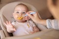 Mother feeding baby boy sitting in high chair Royalty Free Stock Photo