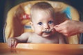 Mother feeding baby boy with a spoon Royalty Free Stock Photo