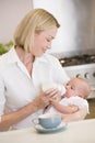 Mother feeding baby with coffee smiling Royalty Free Stock Photo