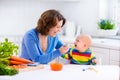 Mother feeding baby first solid food