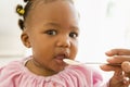 Mother feeding baby food to baby