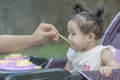 Mother feeding baby girl with porridge.