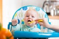 Mother feeding capricious baby with a spoon