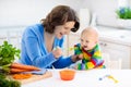 Mother feeding baby first solid food