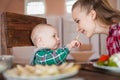 Mother feeding child. First solid food for young kid Royalty Free Stock Photo