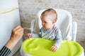 Mother feeding child. First solid food for young kid. Healthy nutrition for children Royalty Free Stock Photo