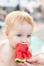 Mother feeding cute adorable caucasian blond little toddler boy slice of fresh sweet tasty watermelon at vacation on sea or ocean Royalty Free Stock Photo