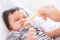 Mother feeding cute asian baby girl with a spoon at home Royalty Free Stock Photo