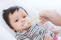 Mother feeding cute asian baby girl with a spoon at home Royalty Free Stock Photo