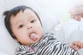 Mother feeding cute asian baby girl with a spoon at home Royalty Free Stock Photo