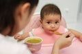 mother feeding food to her infant baby eating with spoon at home Royalty Free Stock Photo