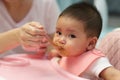 mother feeding food to her infant baby eating with spoon at home Royalty Free Stock Photo