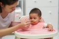 mother feeding food to her infant baby eating with spoon at home Royalty Free Stock Photo