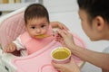 mother feeding food to her infant baby eating with spoon at home Royalty Free Stock Photo