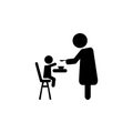 Mother feeding her baby child sitting on kids eating chair. Royalty Free Stock Photo