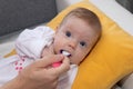 Mother feeding her baby girl with spoon. Happy little cute daughter with blue eyes. The baby girl is four months old Royalty Free Stock Photo