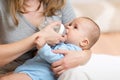 Mother feeding her baby infant from bottle