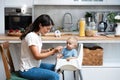 Mother feeding her baby son or daughter with spoon. Mother giving healthy food to her adorable child at home. Lovely mommy and her Royalty Free Stock Photo