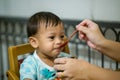 Mother feeding her baby with spoon. Mother giving healthy food to her adorable child at home. Royalty Free Stock Photo