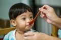 Mother feeding her baby with spoon. Mother giving healthy food to her adorable child at home. Royalty Free Stock Photo