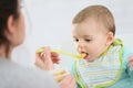 Mother feeding her child with stewed fruits Royalty Free Stock Photo