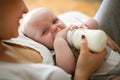 Mother feeding her crying little baby boy with milk. Royalty Free Stock Photo