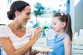 Mother feeding her daughter with cake Royalty Free Stock Photo