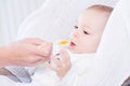 Mother feeding her lovely smiling baby boy with spoon Royalty Free Stock Photo