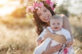 Mother feeding her newborn baby boy from bottle outdoors in the field. artifitial milk feedng Royalty Free Stock Photo