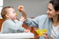 Mother feeding her one year baby boy with a spoon. Royalty Free Stock Photo