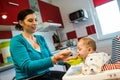 Mother feeding baby first solid food. food diversification Royalty Free Stock Photo