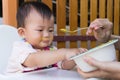 Mother feeding solid food for young kid eight month at home. Royalty Free Stock Photo