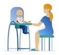 Mother feeding a young child in highchair