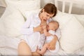 The mother feeds the baby`s chest on the bed, the concept of family baby food