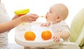 Mother feeds baby spoon on table home